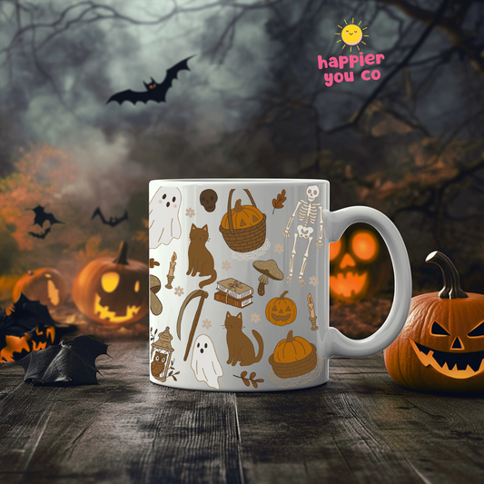 A white ceramic mug with a Halloween-themed pattern of ghosts, skeletons, pumpkins, and mushrooms, displayed on a dark wooden table with jack-o'-lanterns and bats in the background. The 'happier you co' logo is visible in the top right corner.